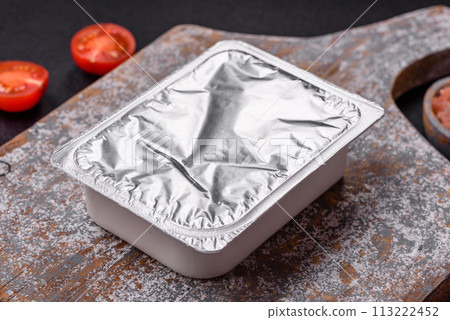 Rectangular plastic box with yogurt or cheese hermetically sealed with a foil lid Rectangular plastic box with yogurt or cheese hermetically sealed with a foil lid 113222452