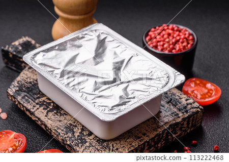 Rectangular plastic box with yogurt or cheese hermetically sealed with a foil lid Rectangular plastic box with yogurt or cheese hermetically sealed with a foil lid 113222468