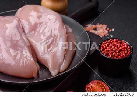 Fresh chicken fillet on a dark concrete table with spices and herbs Fresh chicken fillet on a dark concrete table with spices and herbs 113222509