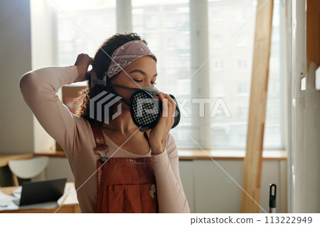 Woman putting on protective respirator 113222949