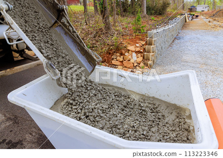 Construction site concrete buggy with wheelbarrow track wet cement in cement truck chute Construction site concrete buggy with wheelbarrow track wet cement in cement truck chute 113223346