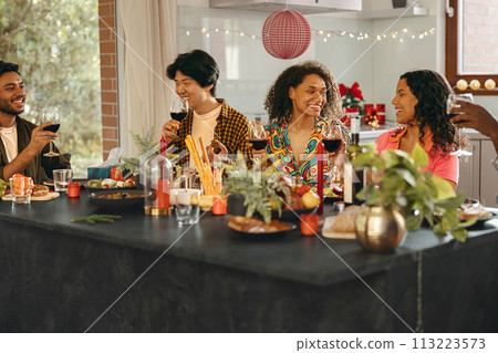 Happy young friends drinking red wine and enjoying time together at holiday party at home Happy young friends drinking red wine and enjoying time together at holiday party at home 113223573