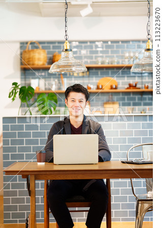 Male nomad worker using a laptop in a cafe Male nomad worker using a laptop in a cafe 113223670