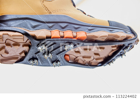 Anti-slip studded lining on sole of boots, improving traction on slippery roads during winter ice. 113224402
