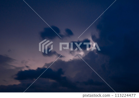 Evening thunderstorm with lightning in the mountains. Dramatic clouds during a thunderstorm pierce the light of lightning in a mountainous area. Evening thunderstorm with lightning in the mountains. Dramatic clouds during a thunderstorm pierce the light of lightning in a mountainous area. 113224477