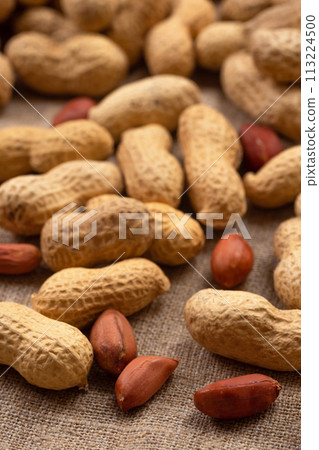 Delicious shelled peanuts on burlap. Peanut background 113224500