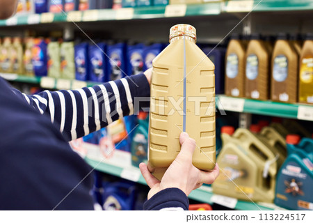 Man chooses oil for car engine in shop 113224517