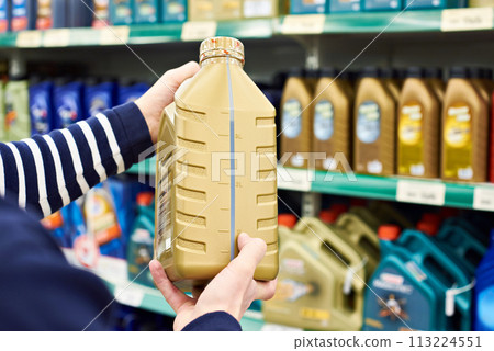 Man chooses oil for car engine in shop Man chooses oil for car engine in shop 113224551