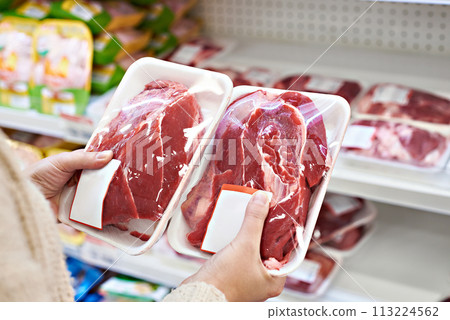 Buyer hands with beef meat packages at grocery 113224562
