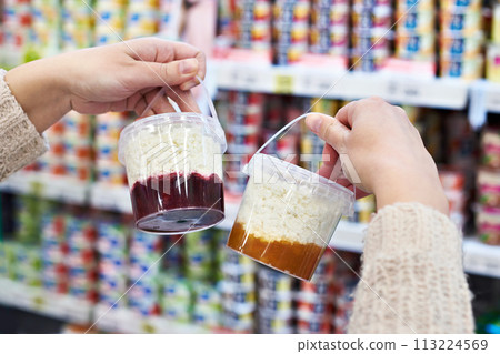 Hands with plastic container cottage cheese with jam in grocery 113224569