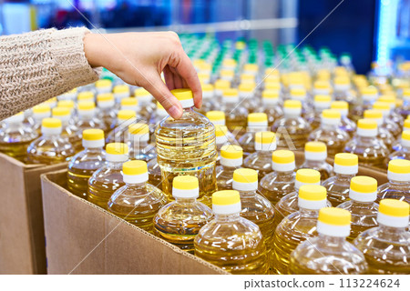 Hand with sunflower oil packaging in store Hand with sunflower oil packaging in store 113224624