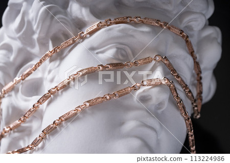 Gold chain on the stone face of the sculpture. Gold chain on the stone face of the sculpture. 113224986