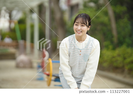 Nursery teacher watching over children in the park 113227001