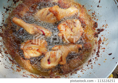 Delicious Fried Chicken in a Sizzling Hot Pan with Skillful Chef Expertise 113228251