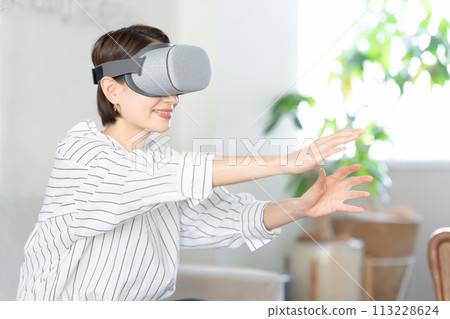A woman enjoying herself while wearing VR goggles A woman enjoying herself while wearing VR goggles 113228624