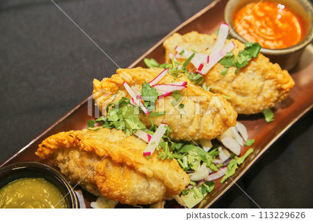 Hand-Crimped Empanadas with Fresh Garnish and Salsas Hand-Crimped Empanadas with Fresh Garnish and Salsas 113229626