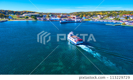 Aerial View of Ferry Boat and Coastal Town on Calm Blue Waters 113229729