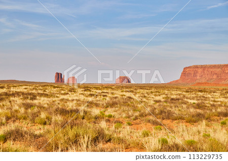 Serene Southwest Desert Landscape with Red Sandstone Buttes and Blue Sky Serene Southwest Desert Landscape with Red Sandstone Buttes and Blue Sky 113229735