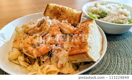 Shrimp Fettuccine Pasta Meal with Toast and Caesar Salad 113229849