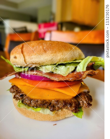 Gourmet Cheeseburger with Bacon and Fresh Toppings, Eye-Level View Gourmet Cheeseburger with Bacon and Fresh Toppings, Eye-Level View 113230176