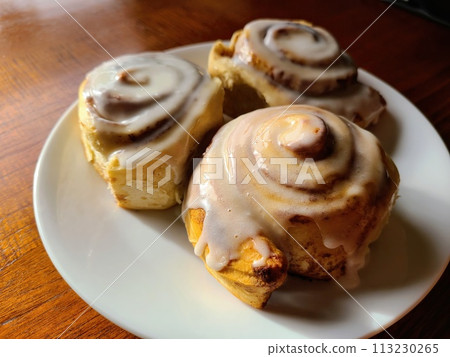 Fresh Cinnamon Rolls with Melting Frosting, Eye-Level View 113230265