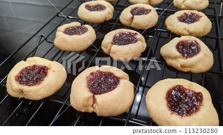 Freshly Baked Thumbprint Cookies with Jam on Cooling Rack Freshly Baked Thumbprint Cookies with Jam on Cooling Rack 113230280