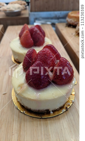 Gourmet Strawberry Cheesecake on Wooden Surface, Eye-Level View Gourmet Strawberry Cheesecake on Wooden Surface, Eye-Level View 113230389