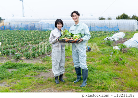 Young male and female farmers holding crops 113231192