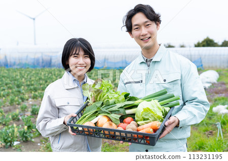 Young male and female farmers holding crops 113231195