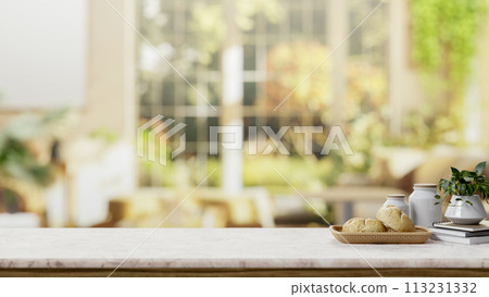 A space on a white marble table with a blurred background of a bright living room with green garden. 113231332