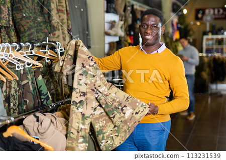 Man choosing camouflage clothes 113231539