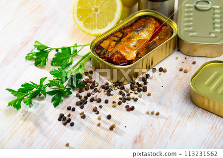 Open can of sardines on table 113231562