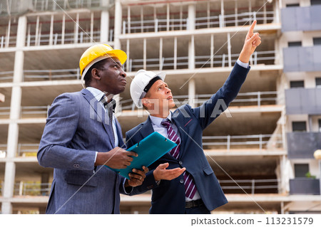 Two engineers discussing new construction Two engineers discussing new construction 113231579