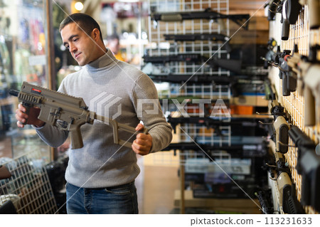 Man chooses semi-automatic pneumatic assault rifle at gun store 113231633