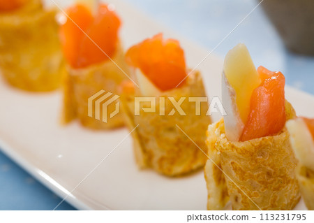 Pancakes rolls with salted salmon on a plate Pancakes rolls with salted salmon on a plate 113231795