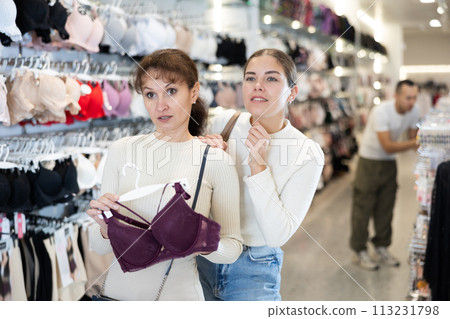 Adult and young women choosing bra in store Adult and young women choosing bra in store 113231798