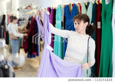 Adult woman choosing dress in store 113231828