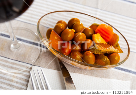 Tasty small serving of olives with carrots pickles and onions 113231894