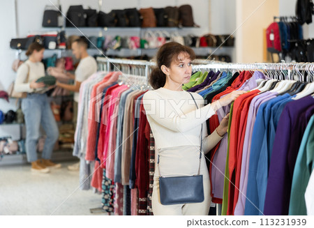 Adult woman choosing sweatshirt in store Adult woman choosing sweatshirt in store 113231939