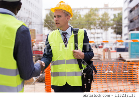 Successful architect and engineer shake hands on construction site Successful architect and engineer shake hands on construction site 113232135