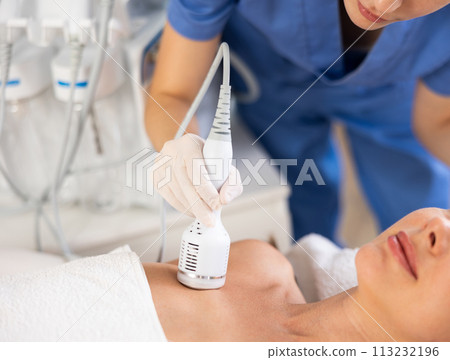 Female patient receiving hardware procedure on chest and neck area using cooling attachment 113232196