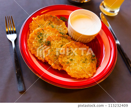 Fried grated potato pancakes with sour cream 113232409