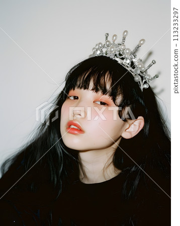 Asian girl wearing a kitschy crown Asian girl wearing a kitschy crown 113233297
