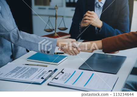 Businessman shaking hands to seal a deal with his partner lawyers or attorneys discussing a contract agreement. Businessman shaking hands to seal a deal with his partner lawyers or attorneys discussing a contract agreement. 113234644