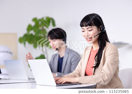Young men and women working in a business call center 113235065