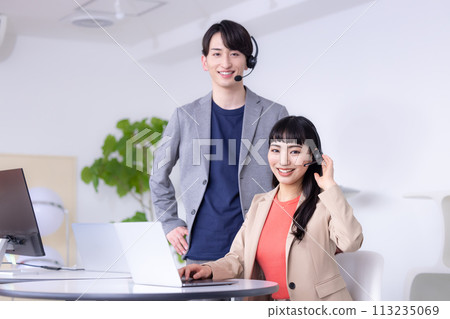 Young men and women working in a business call center 113235069