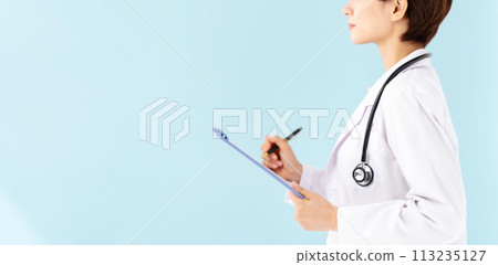 A woman in a white coat holding a medical record in her hand 113235127