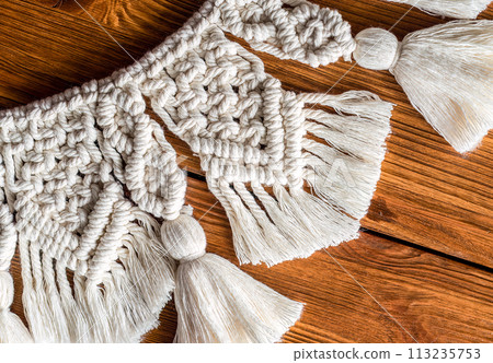 curtain tieback in boho style on wooden shelf 113235753