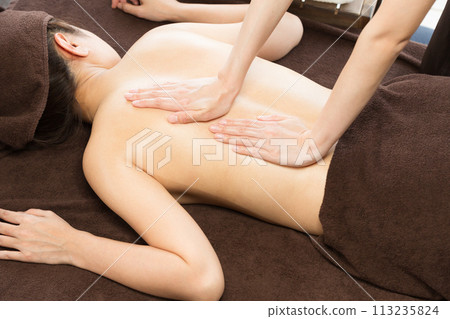 Woman receiving back oil massage 113235824