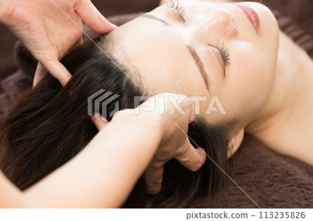 A woman is receiving a head massage. 113235826